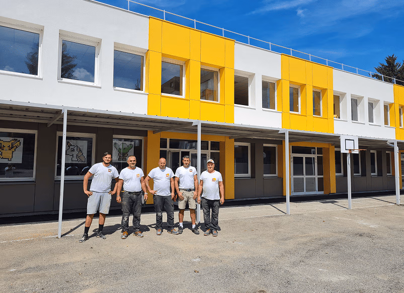 Équipe de compagnons du Groupe Chanel devant un bâtiment rénové